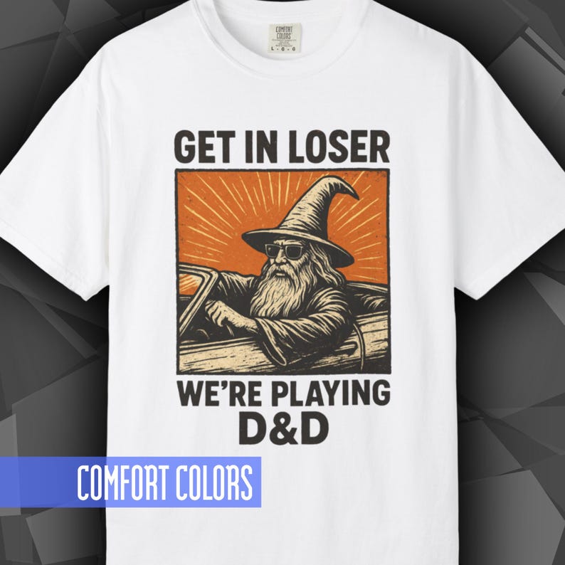 Comfort Colors T-shirt with a D&D funny meme/Dungeons & Dragons graphic. The shirt is 100% cotton, premium quality, available in 14 colors, unisex fit, plus size options. RPG tabletop role play gamer apparel. T-shirt featuring a wizard in a car and the text "Get In Loser We're Playing D&D".