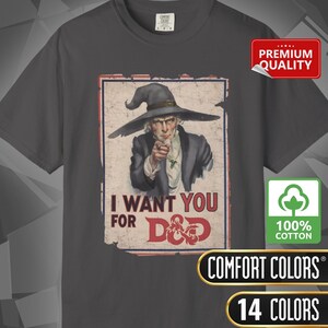 May include: Dark gray t-shirt featuring a vintage-style poster of Uncle Sam with the text "I WANT YOU FOR D&D." The shirt includes the Comfort Colors logo and a "100% Cotton" label.