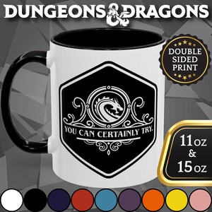 May include: A white ceramic mug with a black handle and interior. The mug features a black and white design with the text "YOU CAN CERTAINLY TRY." and a dragon graphic. The mug is available in 11 oz and 15 oz sizes.