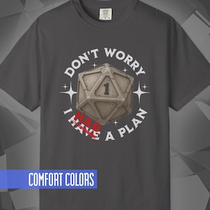 May include: Dark gray t-shirt with the text "DON'T WORRY I HAVE A PLAN" surrounding a 20-sided die with the number 1. The words "I HAVE" are in red. The shirt also has the words "COMFORT COLORS" in a blue rectangle.