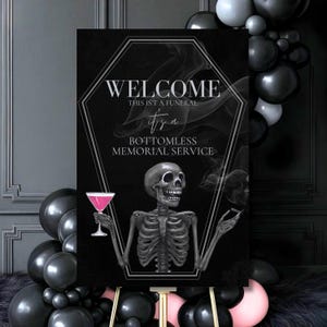 May include: Black sign with the text "WELCOME, THIS ISN'T A FUNERAL, it's a BOTTOMLESS MEMORIAL SERVICE." A skeleton illustration holds a pink cocktail and a cigarette. Black and pink balloons surround the sign.
