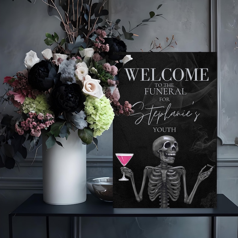 May include: A black sign with the text "WELCOME TO THE FUNERAL FOR Stephanie's YOUTH" and a skeleton illustration holding a pink cocktail. A white vase with a floral arrangement of black, white, and pink flowers sits to the left.
