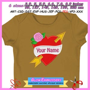 Könnte beinhalten: Senffarbener Baby-Body mit einem roten Herz, das von einem goldenen Pfeil durchbohrt wird, einer rosa Rose und dem Text "Your Name" auf einem weißen Banner. Erhältlich in 6 Größen, von 99 mm bis 228 mm.