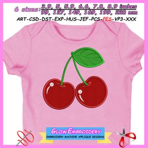 Könnte beinhalten: Rosa Baby-Body mit Kirschdesign. Die Kirschen sind rot mit weißen Highlights, grünen Stielen und einem grünen Blatt. Der Text "GLOW EMBROIDERY EMBROIDERY MACHINE APPLIQUE DESIGNS" befindet sich unten.