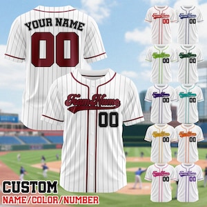 May include: White baseball jersey with vertical pinstripes and maroon accents. The front features "Team Name" and the number "00". The back displays "YOUR NAME" and "00". Additional jerseys with different color accents are also shown. The text "CUSTOM NAME/COLOR/NUMBER" is at the bottom.