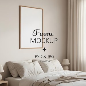 May include: A framed mockup with the text "Frame MOCKUP" and "PSD & JPG Download" is displayed above a bed with white bedding. The frame has a light brown wooden border. The room has a neutral color palette.