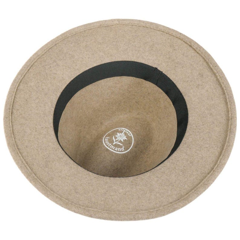 May include: A tan-colored fedora-style hat with a wide brim and a black band. The interior is a lighter tan color with a white logo that reads "original austmann".