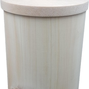 May include: A light-colored wooden container with a lid and a small knob. The cylindrical body has vertical grain patterns, and the lid is flat. The knob is a small, rounded shape. The container is likely for storage.