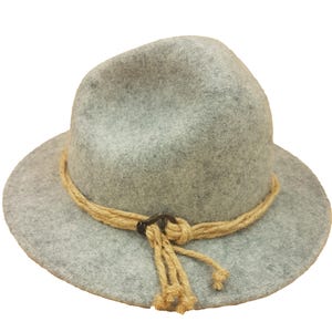 May include: A gray fedora-style hat with a wide brim. The hat features a tan rope band with a decorative knot and tassel. The hat is made of a soft, felt-like material.