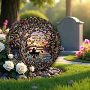 Könnte beinhalten: Runde Gedenktafel mit einem Lebensbaum-Design, die einen Fischer in einem Boot auf einem See bei Sonnenuntergang zeigt. Der Text lautet "Jemand, den ich liebe, fischt im Himmel" und "Opa 1941-2024". Die Tafel hat einen dekorativen Rand.