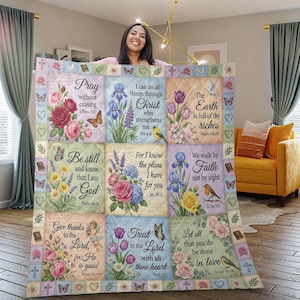Può includere: Una coperta trapuntata con disegni floreali e citazioni ispiratrici. La coperta presenta quadrati con immagini di fiori, farfalle e uccelli, insieme a testi religiosi come "Pregate incessantemente" e "Confida nel Signore".
