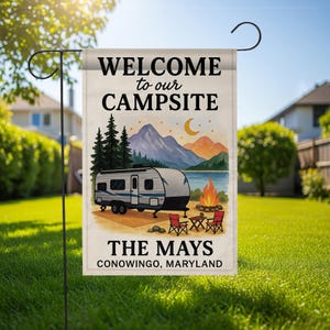 May include: A rectangular garden flag featuring the text "WELCOME to our CAMPSITE" above a camper illustration, lake, mountains, and campfire. The text "THE MAYS CONOWINGO, MARYLAND" is at the bottom.