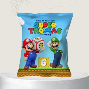 May include: A blue and green party favor bag with a Mario and Luigi theme. The bag features the text "Time to level up! SUPER THOMAS is turning 6".