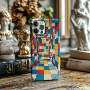 May include: A phone case with a geometric design in a perspective view of a hallway. The case features a pattern of red, yellow, blue, and white squares. The phone case is on a wooden surface.