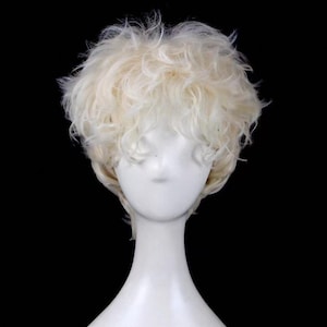 May include: A short, light blonde wig with a slightly tousled style. The wig is displayed on a white mannequin head against a black background. The hair has a natural, textured appearance.