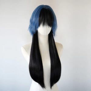 May include: A two-toned wig with a blue top section and long black pigtails. The wig is displayed on a mannequin head against a white background. The blue section has a wavy texture, while the black hair is straight.