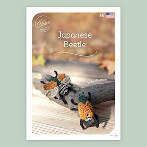 May include: A crochet pattern for a "Japanese Beetle" with two handmade beetles in tan, black, and green. They are positioned on a wooden branch. The background is blurred. The pattern is labelled "Crochet Pattern".