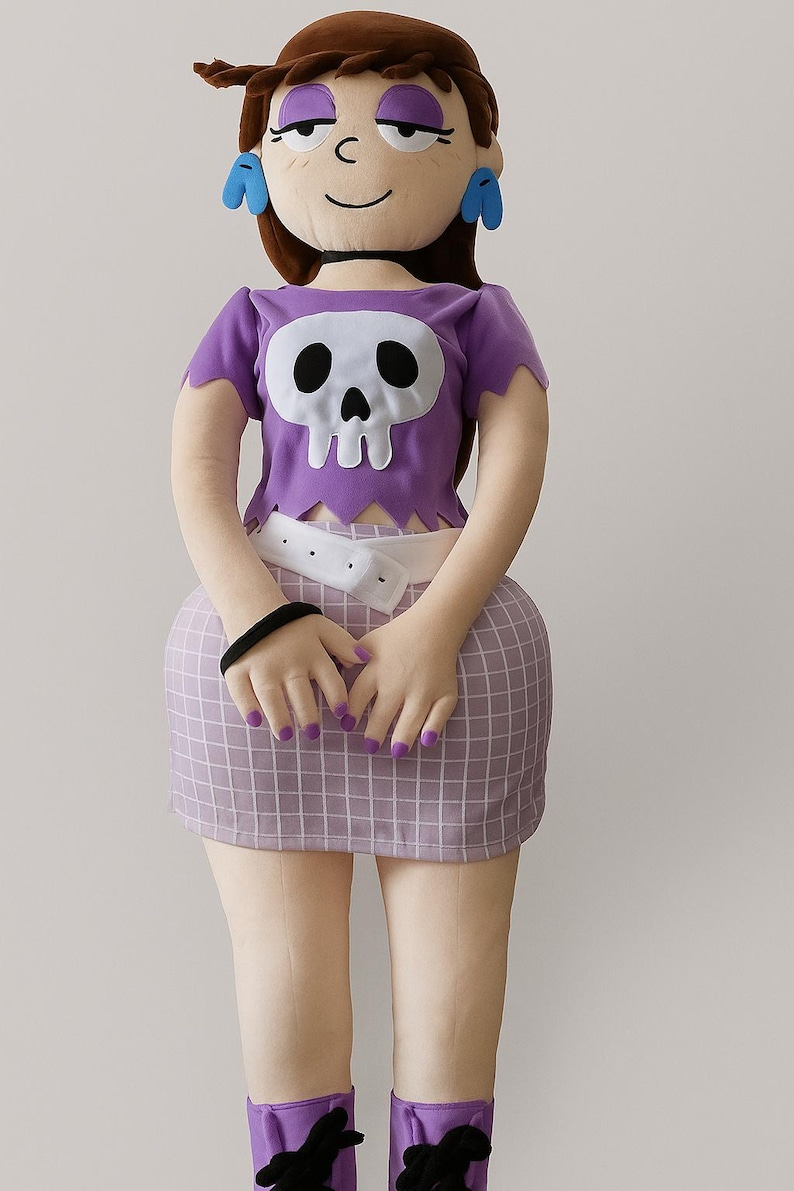 May include: A plush doll of a cartoon character, with a purple top featuring a skull design, a checkered skirt, and purple boots. The doll has brown hair, purple eyeshadow, and blue earrings. The doll is approximately 61 cm tall.