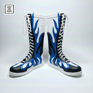 May include: Pair of tall, black, white, and blue boots with a flame design. The boots have white laces and soles. The boots are knee-high and feature the text "Craft Edge Goods" in a square logo.
