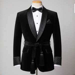 May include: A black velvet tuxedo jacket with a quilted shawl collar, cuffs, and pocket square. The jacket features a matching belt with tassels and a black bow tie. The Craft Edge Goods logo is visible in the upper right corner.
