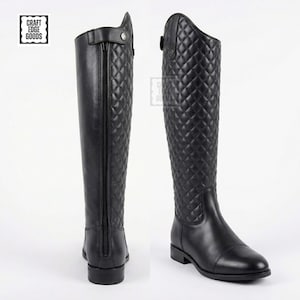 May include: Black leather riding boots with a quilted design on the upper. The boots feature a full-length zip at the back and a small strap at the top. The boots are displayed from the front and side.