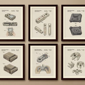 May include: Six framed patent prints featuring vintage video game consoles and controllers. Each print showcases detailed technical drawings of classic gaming devices, including handheld consoles and controllers, in a neutral color palette.