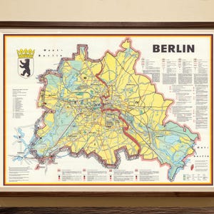 May include: Framed vintage map of Berlin, Germany, with a brown wooden frame. The map features a yellow and blue color scheme, with the city's layout and key landmarks. The word "BERLIN" is displayed at the top.