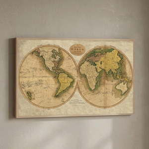 Puede incluir: Una taza de cerámica blanca con asa negra y el texto "But First, Coffee" en negrita negra. La taza se encuentra sobre un fondo borroso, sugiriendo un ambiente acogedor.