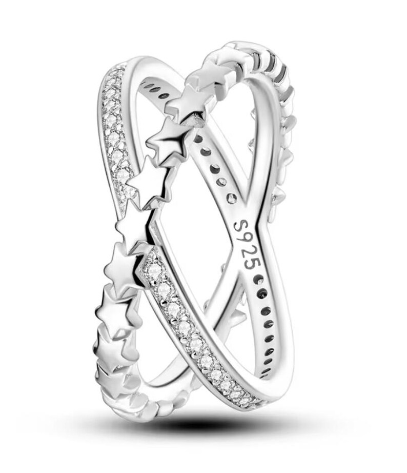 Op de afbeelding: Zilveren ring met een dubbelband ontwerp. Een band heeft een rij kleine, heldere stenen en de andere band heeft een rij ster-uitsnijdingen. De ring is gemarkeerd met "S925" aan de binnenkant.