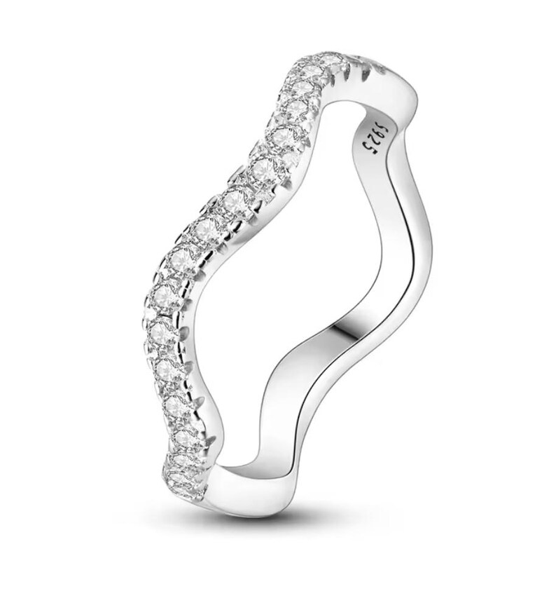 Op de afbeelding: Een zilveren ring met een golvend ontwerp en heldere zirkonia-stenen. De ring is gemarkeerd met het nummer "925".