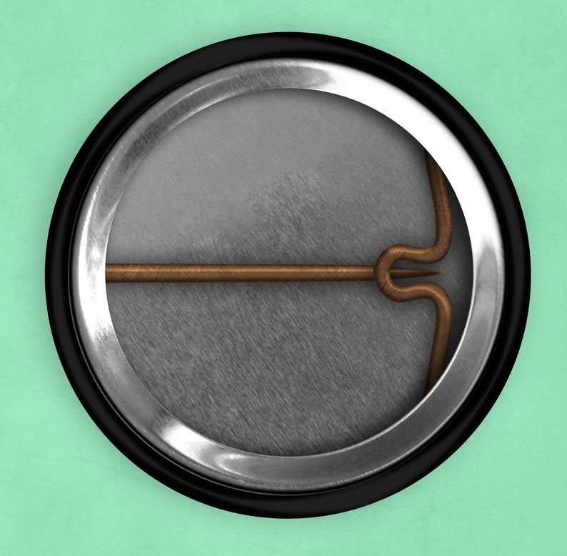 May include: The back of a round button with a silver metal rim and a black plastic backing. A copper-colored pin is attached to the back of the button.