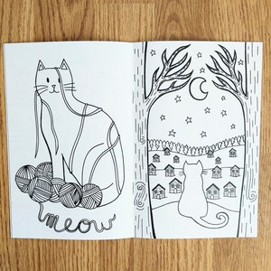 May include: A black and white coloring book page featuring a cat tangled in yarn balls with the word "meow" written below. The second page shows a cat looking out a window at a row of houses under a crescent moon and stars.
