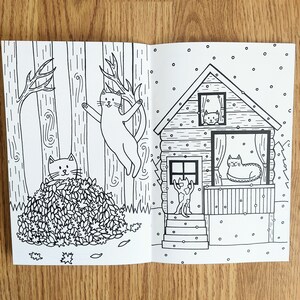 May include: Black and white illustration of a cat climbing a tree, another cat hiding in a pile of leaves, and a third cat looking out of a window in a cabin. The cabin has a porch with a cat sitting on it. The scene is set in a forest with snow falling.