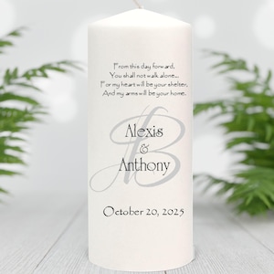 May include: A white pillar candle with a wick, featuring the names "Alexis & Anthony" in elegant script, along with the date "October 20, 2025". The candle also has a romantic quote. The candle is a wedding or anniversary item.