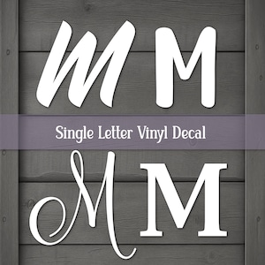 May include: Four white vinyl decals of the letter M in different fonts, displayed on a dark gray wood-grain background. The text Single Letter Vinyl Decal is printed in white across a horizontal purple band centered between the letter designs.