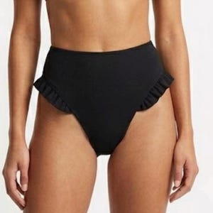 May include: A solid black high-waisted bikini bottom featuring a smooth fabric finish and decorative ruffled trim along the side leg openings. The garment provides full coverage with a high-cut silhouette that sits above the hips.
