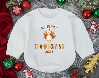 May include: White baby bodysuit with long sleeves. The front features a watercolor turkey illustration and the text "MY FIRST THANKSGIVING 2025" in a mix of colors. Festive holiday decor surrounds the bodysuit.