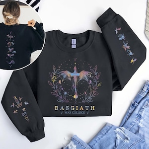 May include: Black sweatshirt with a colorful dragon design, the text "BASGIATH WAR COLLEGE", and illustrations on the sleeves. The back of the sweatshirt has a vertical design of celestial elements.