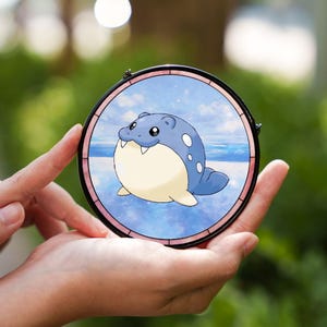 Może przedstawiać: Zestaw trzech ceramicznych kubków z nakrapianym, matowym wykończeniem. Kubki są w odcieniach kremu, jasnoszarym i ciemnoszarym. Każdy kubek ma prosty, minimalistyczny design.