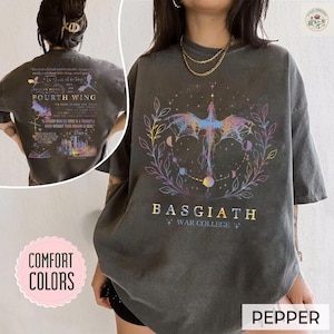 Könnte beinhalten: Pfeffergraues T-Shirt mit einem farbenfrohen Drachendesign und dem Text "BASGIATH WAR COLLEGE". Auf der Rückseite des Shirts steht "FOURTH WING". Das Shirt gehört zur "Comfort Colors"-Kollektion.