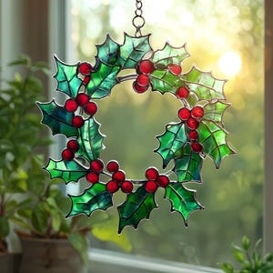 May include: A stained glass holly wreath with green leaves and red berries, suspended by a chain. The circular wreath has a festive, holiday design. The translucent glass allows light to shine through, creating a colourful display.