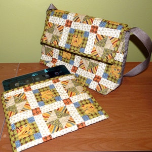 May include: A quilted fabric bag with a brown strap and a matching quilted fabric tablet sleeve. The bag and sleeve feature a patchwork design with green, yellow, orange, and blue squares.