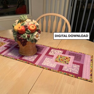 Könnte beinhalten: Lila, Lavendel und gelber Patchwork-Tischläufer mit Blumenmuster. Der Tischläufer liegt auf einem Holztisch mit einer Keramikkobbe.