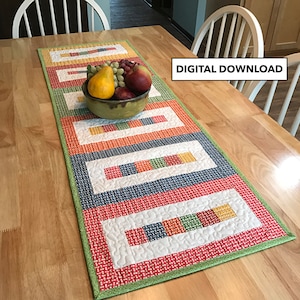 May include: A colourful quilted table runner with a green border and a pattern of squares and rectangles. The runner is on a wooden table with a bowl of fruit in the centre. DIGITAL DOWNLOAD text is visible in the top right corner of the image.