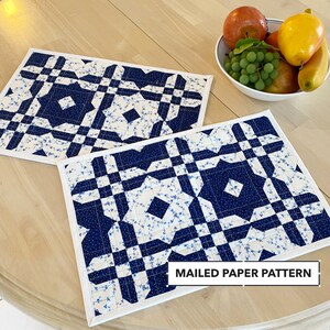 May include: Two blue and white quilted placemats with a white border. The placemats feature a geometric pattern with a floral design. The text "MAILED PAPER PATTERN" is printed on the bottom of the image.