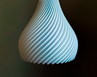 May include: A light blue, teardrop-shaped pendant light fixture. The lamp has a spiral design with evenly spaced ridges. The fixture is suspended from a thin, light-colored cord. The background is a dark, neutral color.