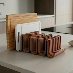 May include: A brown, wavy-shaped kitchen organizer rack holding a rectangular bamboo cutting board and a white plastic cutting board. The rack features multiple vertical slots designed to store flat kitchen items upright in a compact manner.