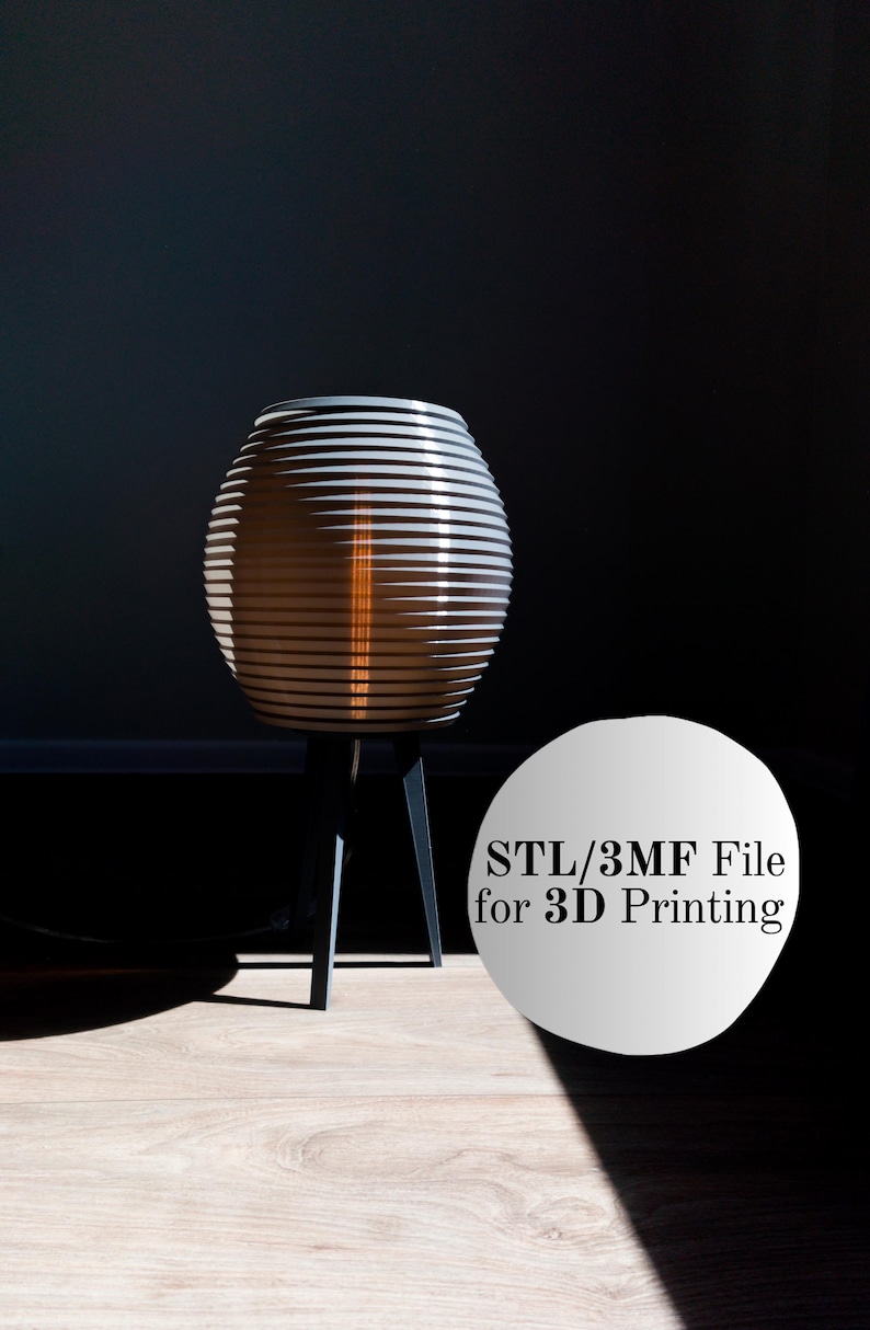 May include: A modern, cylindrical lamp with a layered, striped design. The lamp is supported by three black legs and emits a warm, orange glow. The image includes the text "STL/3MF File for 3D Printing".
