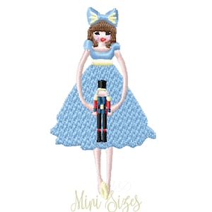 Peut inclure: Motif brodé d'une poupée portant une robe et un nœud bleu clair, tenant un casse-noisette. La poupée a les cheveux bruns et une taille jaune. Le texte "Mini Sizes" est en bas en cursive.