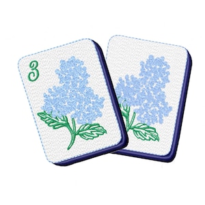 May include: Two rectangular white tiles with blue hydrangea flower embroidery. One tile has a green "3" in the upper left corner. The flowers are light blue with green stems and leaves, and the edges are outlined in dark blue.